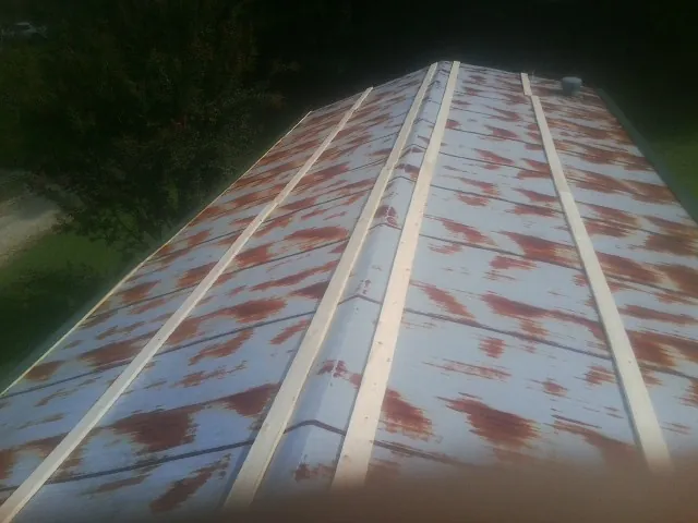 Rusted metal roof panels with new wood purlins before replacement — Storm Damage Roof Repair in Western by Roofing Brothers
