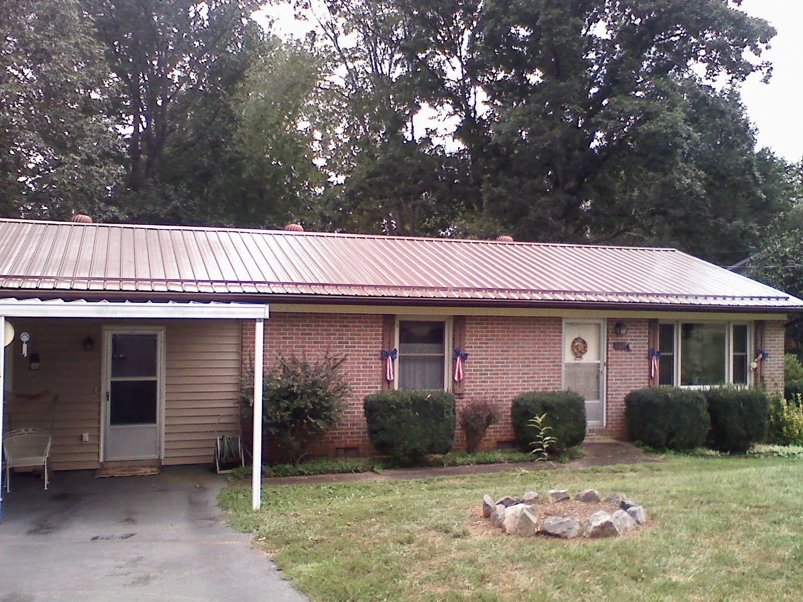 Bronze metal roof and carport on a brick ranch home — Roof Repair work by our crew in Western